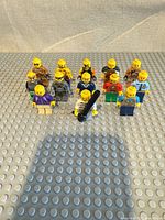 Front view of 13 LEGO minifigures standing on baseplate