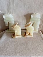 Front view of two onyx horse-head bookends and two seated-figure figurines