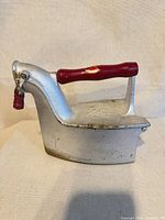 Left side profile of charcoal iron showing body, handle and latch