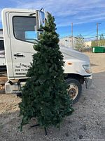 Full view of artificial Christmas tree with stand and lights