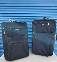 Both suitcases front view against blue door