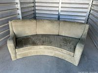 Front view of curved light green sofa showing upholstery and seat cushion