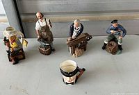 Full group of four figurines and one mug on table