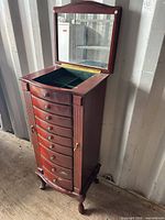 Full view of armoire with lift-top mirror open showing drawers and legs