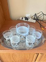 Tray holding one large and six small floral-patterned glasses