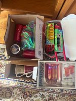 Group shot showing boxed floating candle set, packs of taper and small candles, loose pillar candles, jar candle and pair of JOY mugs