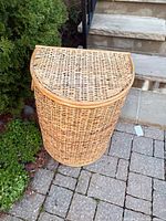 Full view of wicker hamper showing lid and cylindrical shape