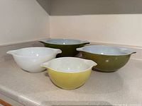 Four coloured Pyrex Cinderella bowls front view