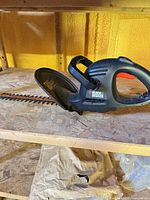 Left side view of Black & Decker corded hedge trimmer on shelf