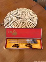 Open gift box showing chopsticks, rests and one trivet