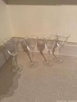 Four crystal port glasses lined up on countertop