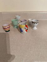 Six assorted ceramic egg cups displayed on countertop
