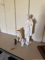 four figurines on shelf showing size relation
