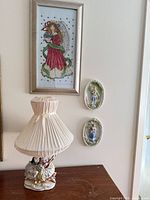Lamp, framed angel needlework, two oval plaques on wall