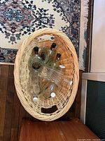 Top view of oval wicker hamper showing six empty bottles inside