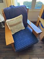 Front view of wooden lounge chair with cushions and throw pillow