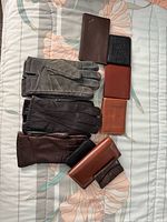 Group of three pairs leather gloves and seven wallets laid out