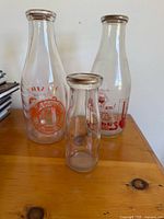 Three glass milk bottles on table