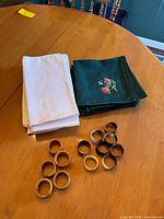 Stacks of green and off-white napkins with wooden rings laid out