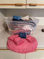 tote of linens with red gingham placemats and napkins displayed
