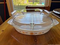 Oval divided casserole with lid, square and rectangular Pyrex baking dishes on table