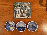 Front view of three souvenir plates and hand-painted Italian tile