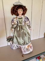 Front view of porcelain doll showing dress, hat, purse