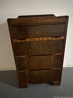 Front view of walnut veneer four-drawer dresser showing bookmatched drawer fronts and banding