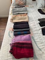 Row of six folded scarves showing colours and textures