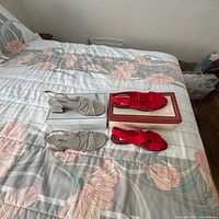 Both pairs of sandals with their boxes on bed