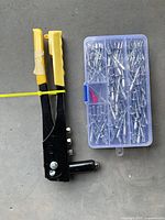Hand rivet tool beside plastic rivet case