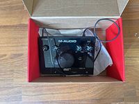 Top view of M-Audio AIR 192|4 in box with USB cable