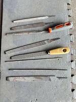 Seven of the nine files and rasps laid out showing profiles and two handle types