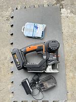 Top view of jigsaw with battery, charger and blade set