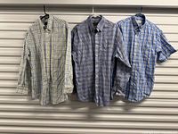 Front view of three Orvis shirts hanging side by side