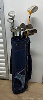 Full view of blue golf bag with clubs