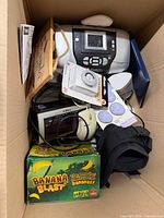 Overview of box showing printer, game, controller, mouse, sign, thermometer