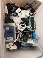 Top view of tote showing mixed chargers, adapters, cables, phone case