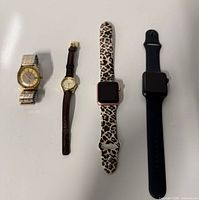 Four watches laid out; shows overall lot contents