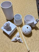 All seven white ceramic decor pieces on table