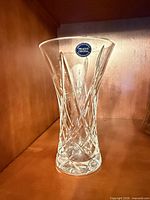 Full view of clear cut crystal vase standing on shelf