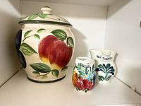 All three ceramic pieces grouped on shelf