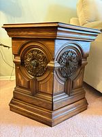 Front and side view of one hexagonal oak veneer end table showing carved floral panel and base details