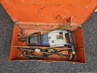 Demolition hammer, cord, bits inside orange case
