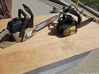 Both Eager Beaver chainsaws side by side on table