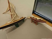 Both model sailboats and stand on display surface