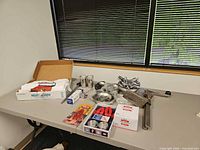 All items laid out on table including bib pack, sword picks, shell crackers, bowls, Zeroll scoop, thermometer, clamp press, spoons