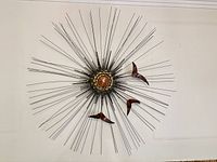 Frontal view of full metal starburst sculpture on wall
