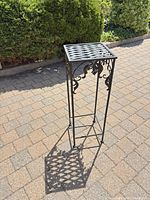 Full view of black wrought iron stand outdoors