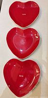 Overhead view of all three red heart plates showing "love" text